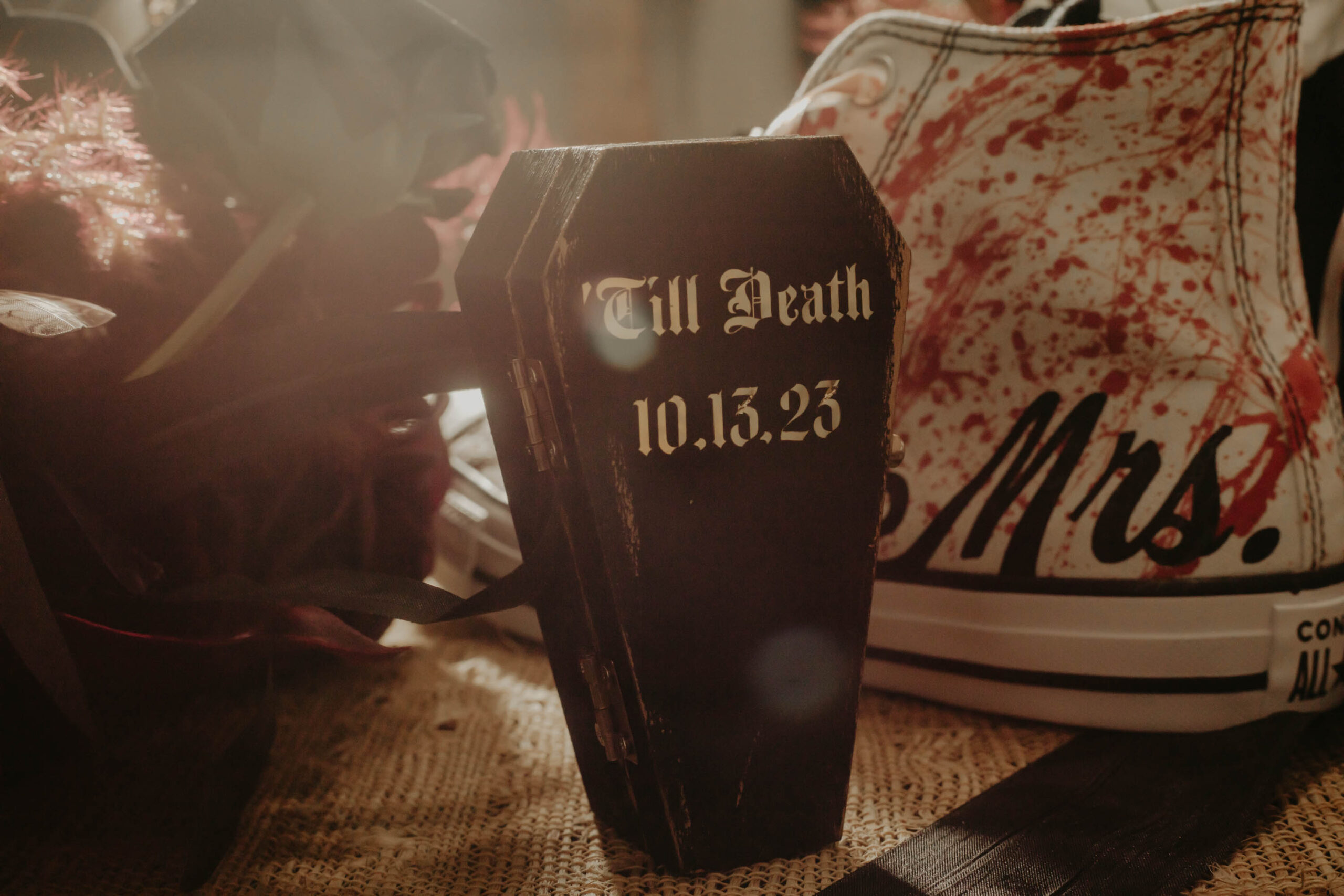 This image is of wedding details. The ring box is a coffin for a Halloween themed wedding.