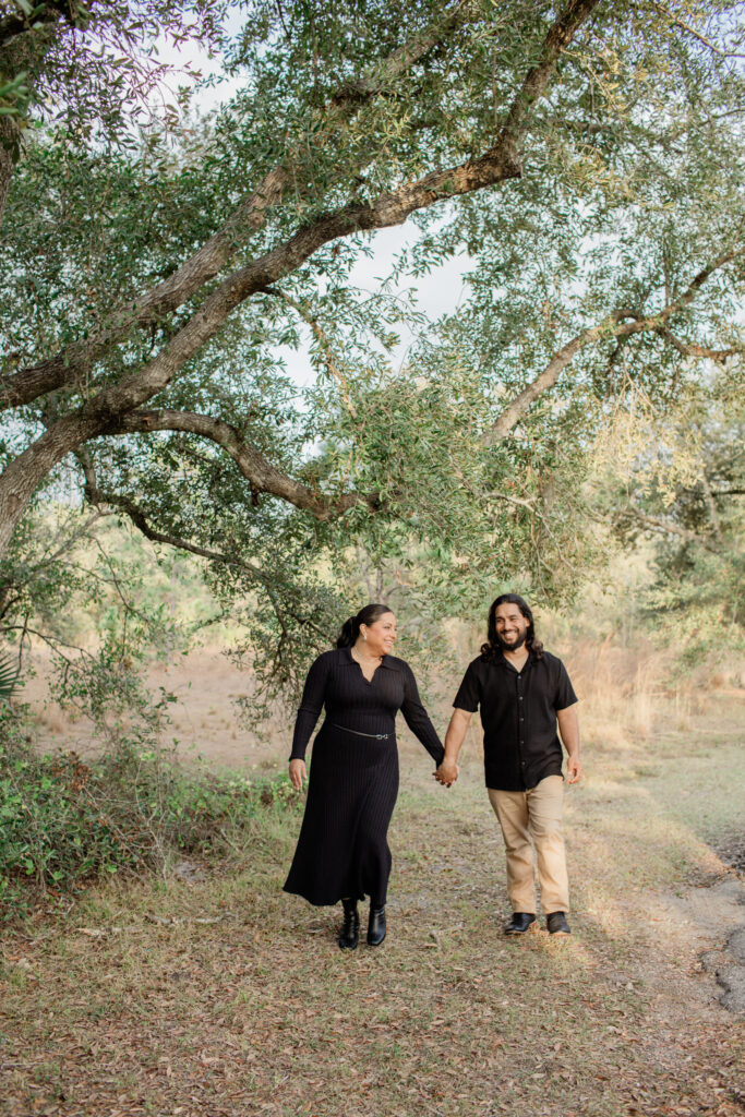 Fort Myers Engagement: Couples is walking hand in hand smiling. 