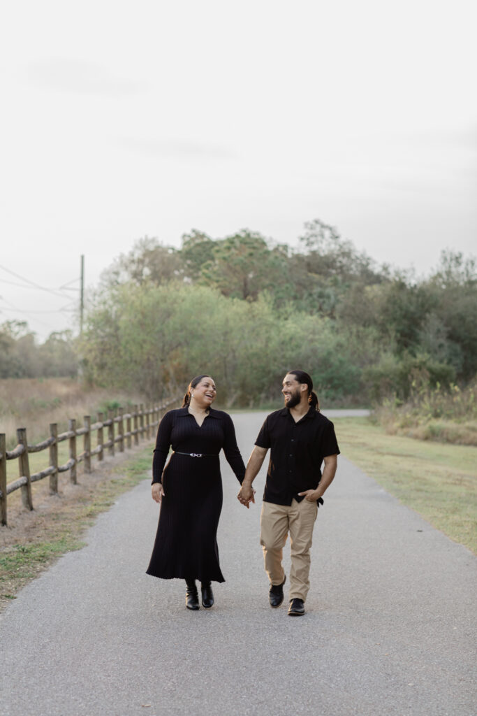 Fort Myers Engagement: Couples is walking hand in hand smiling. 