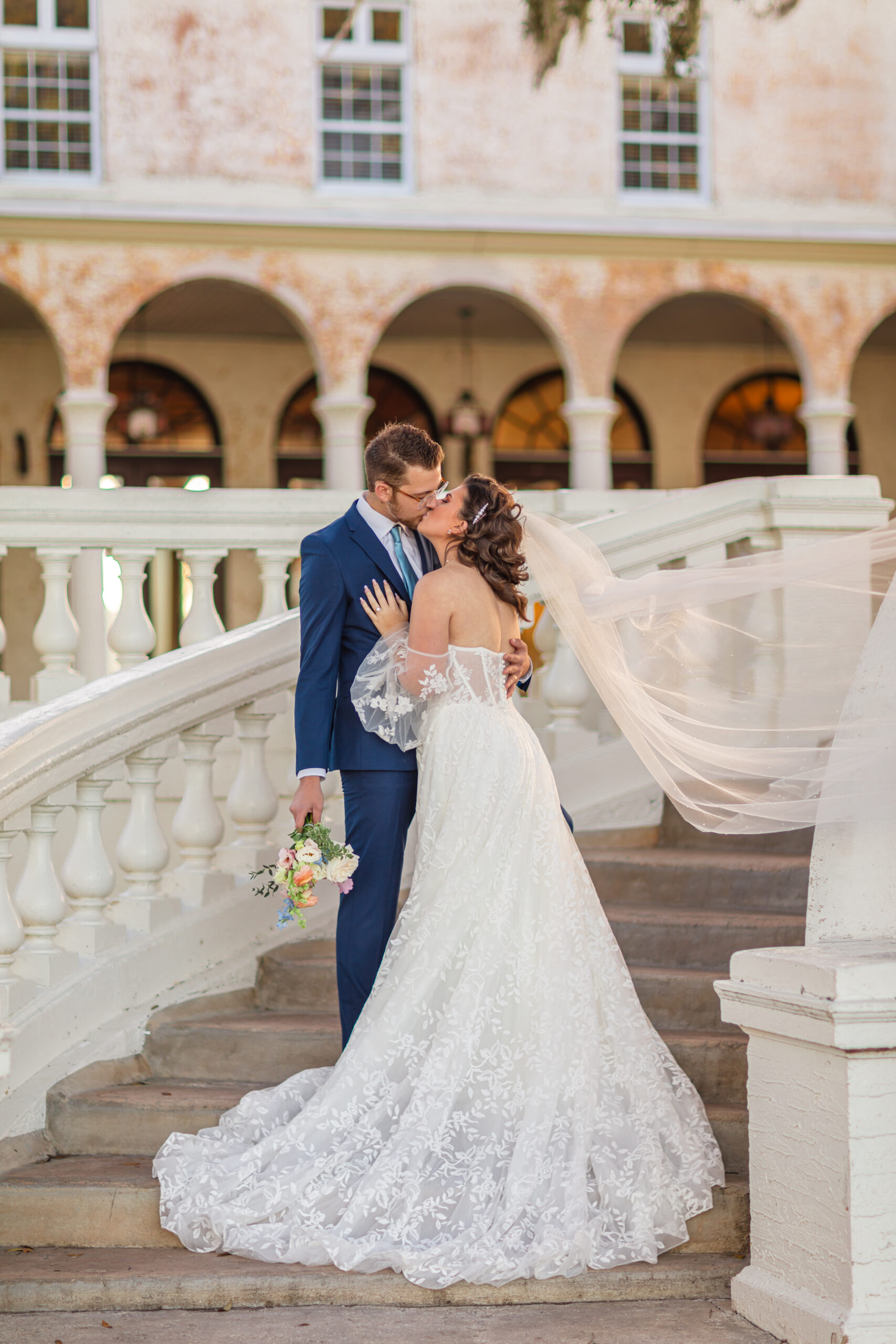 This image is of a bride and groom having a first kiss at Bella Cosa Wedding Venue in Lake Wells Florida.